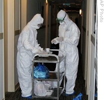 Workers in protective clothing prepare a meal for a quarantined person in Lingang, China