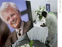 A visitor writes his sympathies in a book to honor Senator Kennedy at the John F. Kennedy Presidential Library in Boston