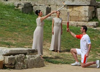 The&nbsp;High&nbsp;Priestess,&nbsp;actress&nbsp;Maria&nbsp;Nafpliotou,&nbsp;kindles&nbsp;a&nbsp;torch&nbsp;held&nbsp;by&nbsp;Alexandros&nbsp;Nikolaidis,&nbsp;Greece's&nbsp;Olympic&nbsp;silver&nbsp;medallist&nbsp;for&nbsp;taekwondo.