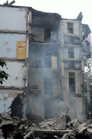 组图:幸存少年从废墟中抢救出生活物资