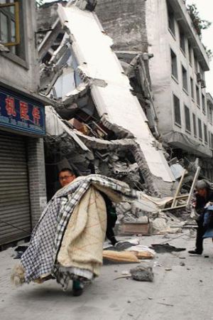 组图:幸存少年从废墟中抢救出生活物资