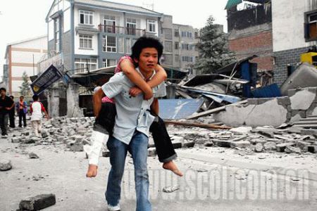 组图:幸存少年从废墟中抢救出生活物资