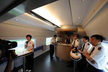 A journalist reports before the bar on the intercity train between Beijing and Tianjin, while the train is on its way from Tianjin to Beijing, Aug. 1, 2008. (Xinhua/Wang Yebiao)