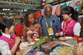 Two customers from Santa Lucia choose clothes in the Xiushui Market, also known as the Silk Street, in Beijing August 14, 2008. Many foreign athletes, reporters, officials and tourists from across the world visit the market selling items with Chinese characteristics during the Beijing Olympic Games, raising the tourists flow in the market to nearly 50,000 persons a day. (Xinhua/He Junchang)