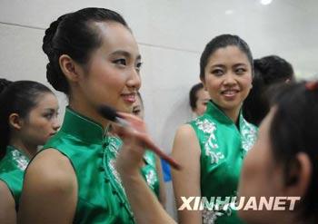 One of ceremony hostesses (L) of the 29th Olympic Games is having her make-up on before a conference to display sport presentations and awarding ceremonies of the 2008 Beijing Olympic Games in the gym of Beijing Institute of Technology in Beijing, July 20, 2008. (Xinhuanet Photo)