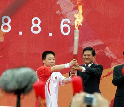 The Olympic torch is delivered from Liu Qi to Yang Liwei.
