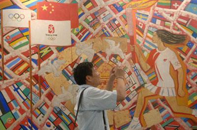 visitor takes photos of an artwork displayed at the China International Exhibition Center in Beijing, capital of China, Aug. 11, 2008. The Olympic Fine Arts 2008, held by the International Olympic Committee (IOC), opened in Beijing Monday, displaying more than 800 works selected from about 10,000 works of more than 40 countries and regions. (Xinhua Photo)